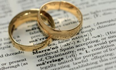 Two wedding rings on a dictionary.